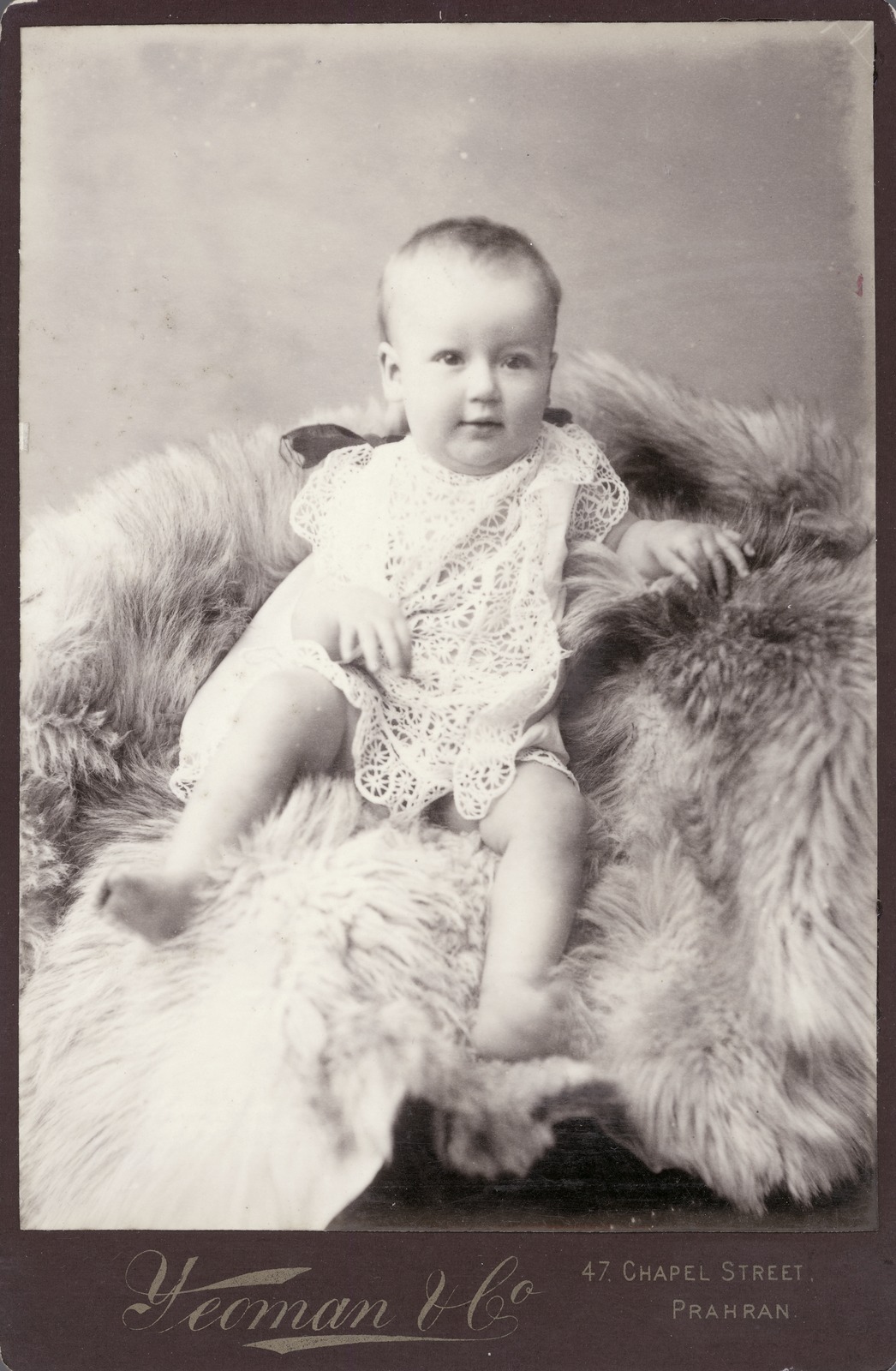 Infant sitting on fur rug